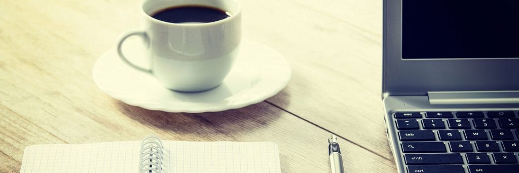 Skrivbord med kaffekopp och dator